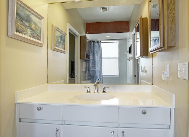 bathroom with visible vents, vanity, and toilet