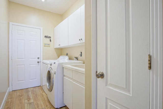 4408 Gator Trace Ln, Fort Pierce, FL 34982 - washroom with cabinet space, light wood finished floors, and washing machine and dryer