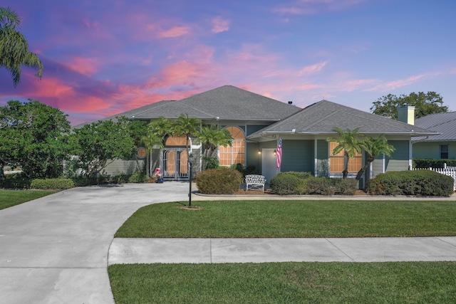 view of front of house with concrete driveway and a front lawn