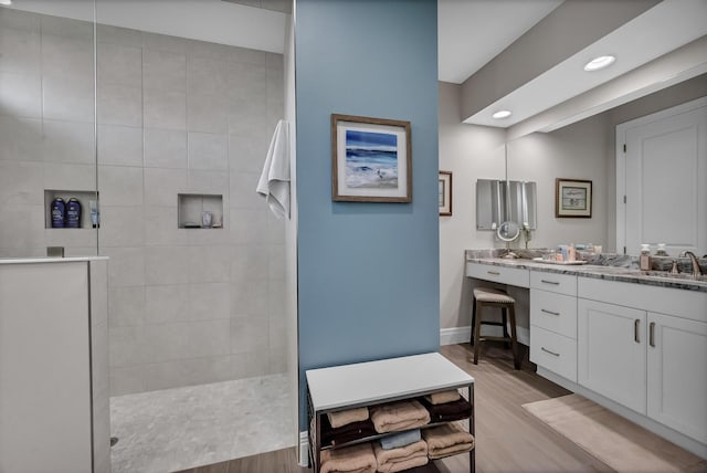 full bathroom featuring baseboards, wood finished floors, walk in shower, vanity, and recessed lighting