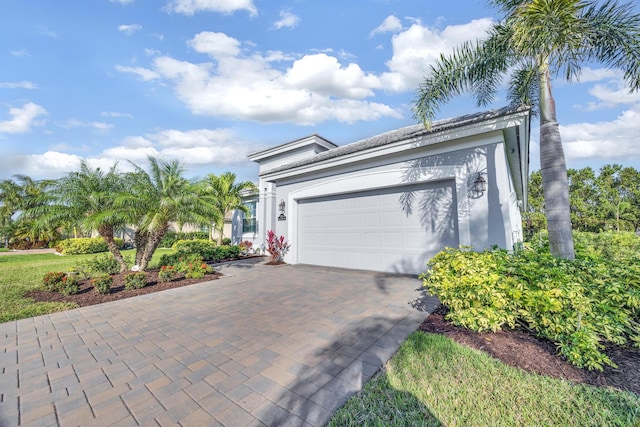 view of front of property with a garage, decorative driveway, and stucco siding