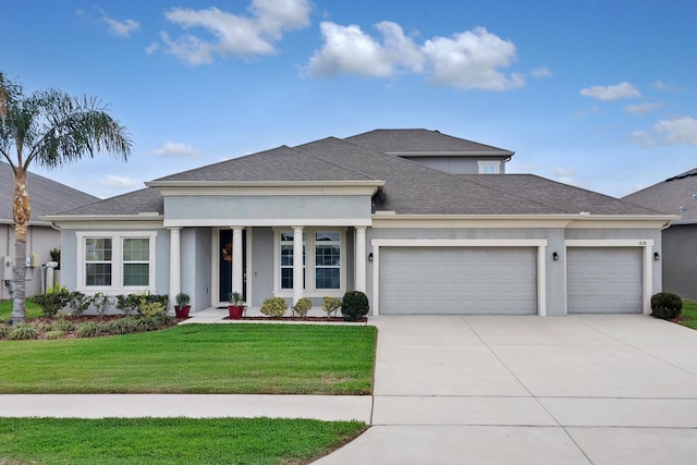 view of front of home with roof with shingles, stucco siding, an attached garage, driveway, and a front lawn