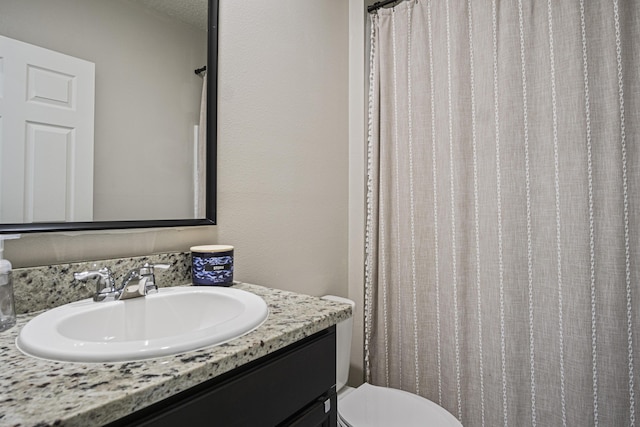 bathroom featuring toilet, curtained shower, and vanity