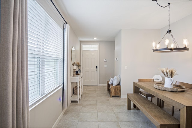 dining room featuring light tile patterned floors, baseboards, and a notable chandelier