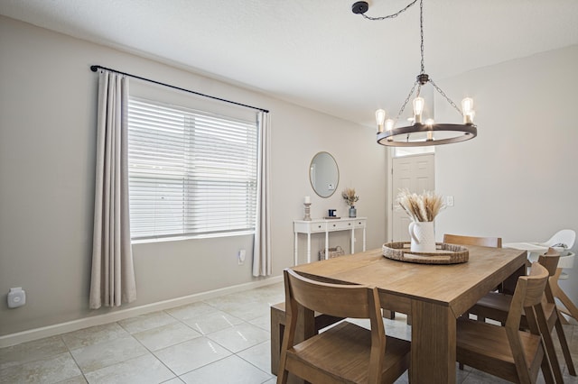 dining room with baseboards, a notable chandelier, and light tile patterned flooring