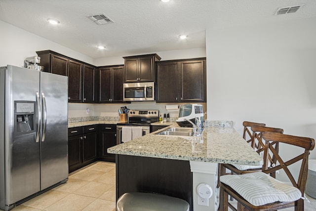 kitchen with a peninsula, visible vents, appliances with stainless steel finishes, and a sink