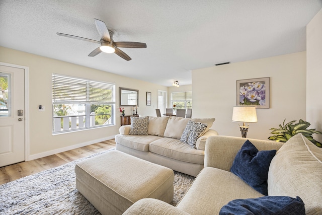 2929 SE Ocean Blvd Unit 10510, Stuart, FL 34996 - living room with wood finished floors, a ceiling fan, baseboards, and a textured ceiling