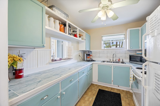 kitchen with blue cabinetry, open shelves, light countertops, a sink, and white appliances