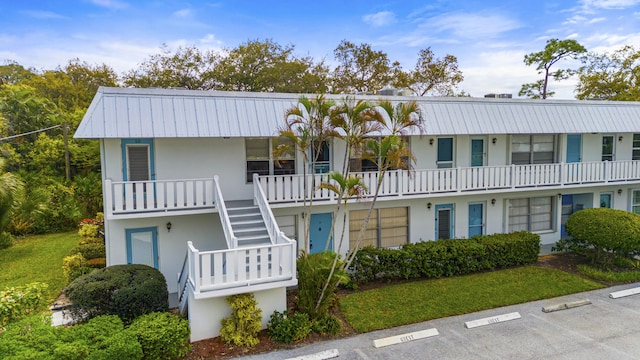 2929 SE Ocean Blvd Unit 10510, Stuart, FL 34996 - view of property featuring stairway and uncovered parking