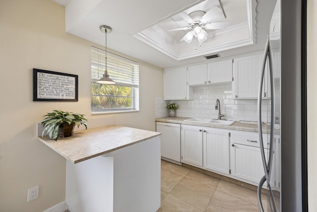 kitchen featuring white cabinets, freestanding refrigerator, white dishwasher, a tray ceiling, and a sink