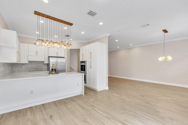 kitchen featuring tasteful backsplash, visible vents, stainless steel appliances, light countertops, and light wood-type flooring