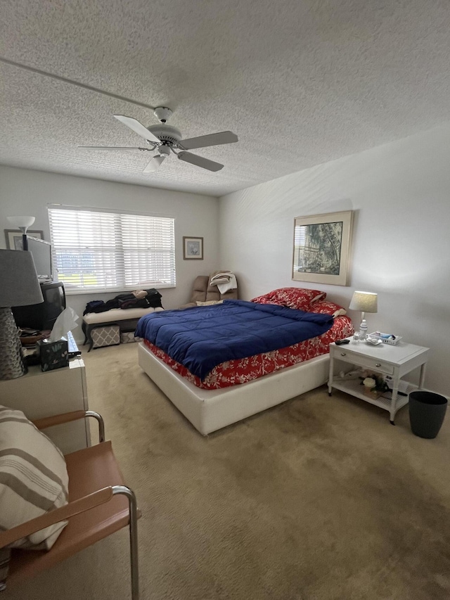 carpeted bedroom featuring ceiling fan and a textured ceiling