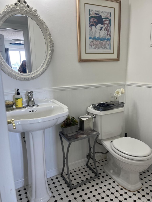 4062 Guildford D, Boca Raton, FL 33434 - half bath featuring toilet, tile patterned flooring, a sink, and a wainscoted wall