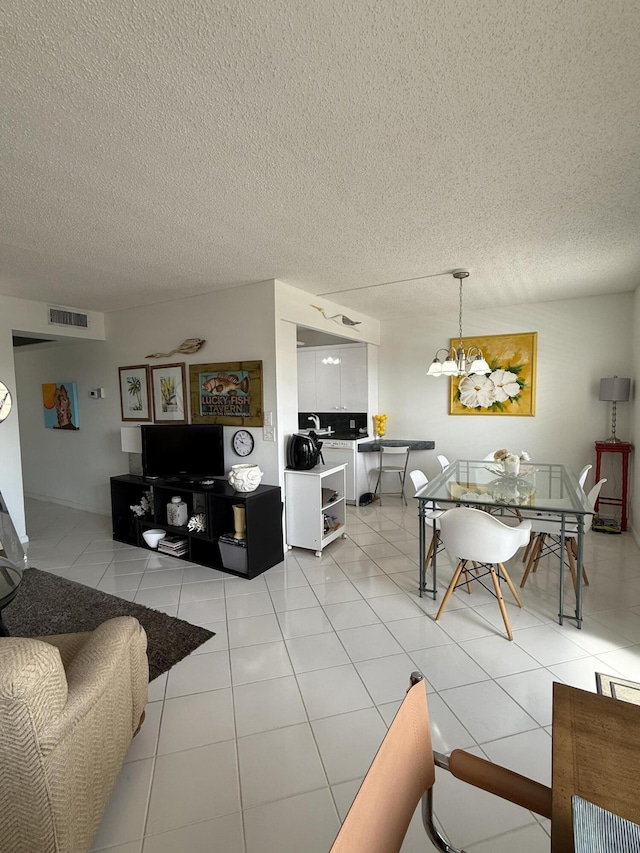 4062 Guildford D, Boca Raton, FL 33434 - living area featuring a chandelier, a textured ceiling, light tile patterned flooring, and visible vents