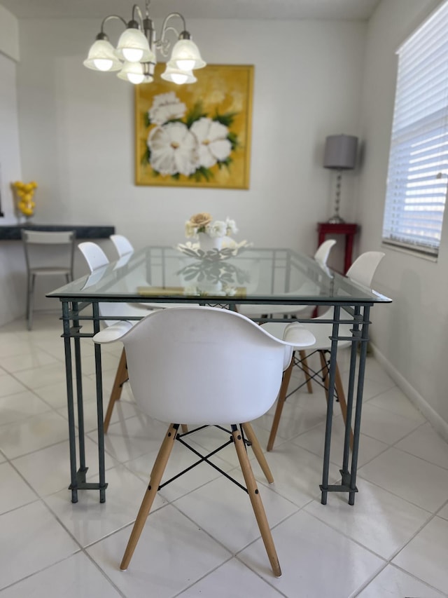 tiled dining area featuring a chandelier and baseboards