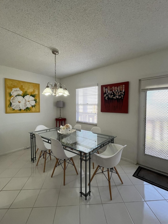 dining room with light tile patterned flooring, a notable chandelier, and a textured ceiling