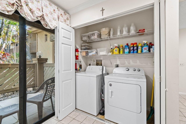 washroom with light tile patterned floors, laundry area, and washing machine and dryer