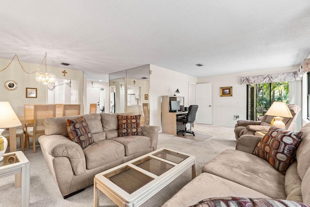 living area with a notable chandelier, a textured ceiling, visible vents, and carpet flooring