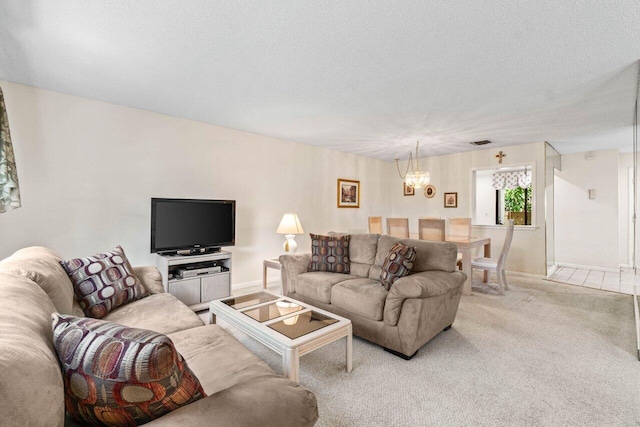 living room featuring light carpet, baseboards, visible vents, an inviting chandelier, and a textured ceiling