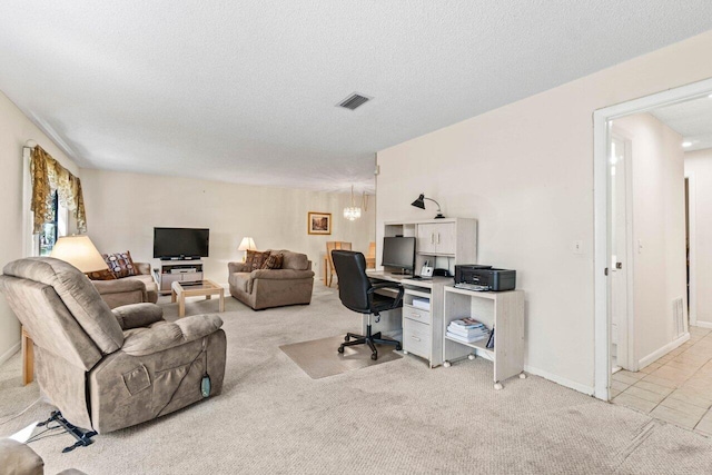 office with visible vents, light carpet, a textured ceiling, and baseboards