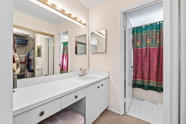 full bathroom featuring curtained shower, baseboards, vanity, and a textured ceiling