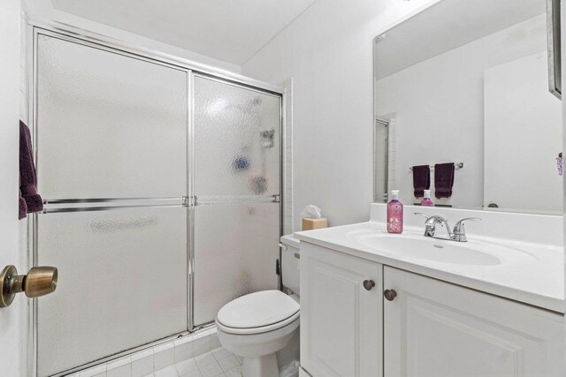 bathroom with a stall shower, tile patterned flooring, vanity, and toilet