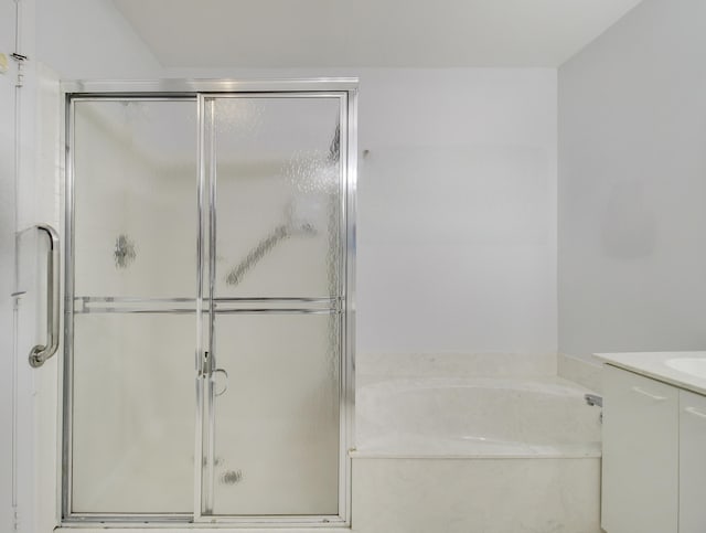 full bathroom featuring a shower stall, vanity, and a bath