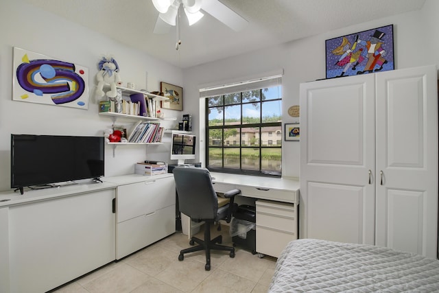 office with built in study area, light tile patterned floors, and a ceiling fan