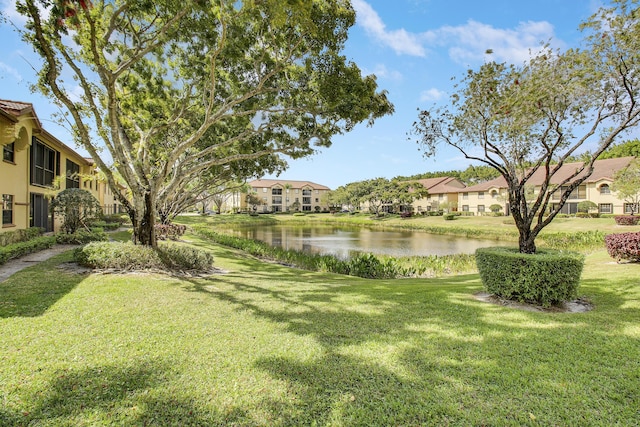 view of yard with a residential view and a water view