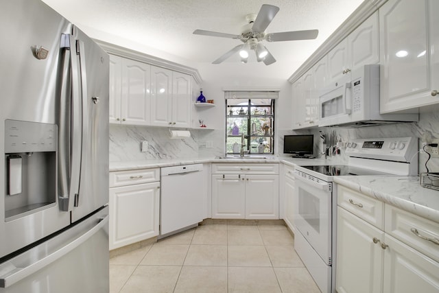 kitchen featuring light tile patterned flooring, a sink, a ceiling fan, white appliances, and decorative backsplash