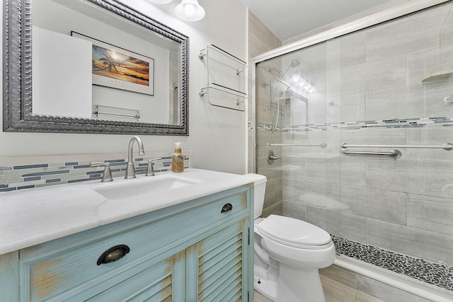 bathroom featuring vanity, tasteful backsplash, a shower stall, and toilet