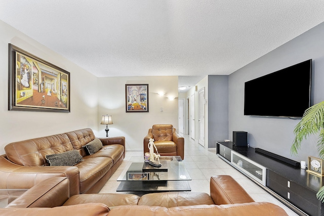 living area featuring a textured ceiling, baseboards, and light tile patterned floors