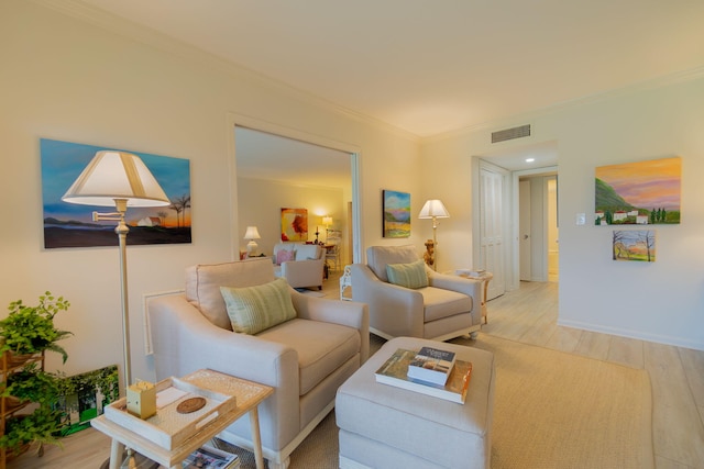 living room with light wood-type flooring, visible vents, crown molding, and baseboards