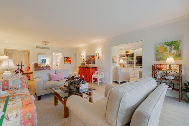 living area with baseboards, light wood finished floors, visible vents, and crown molding