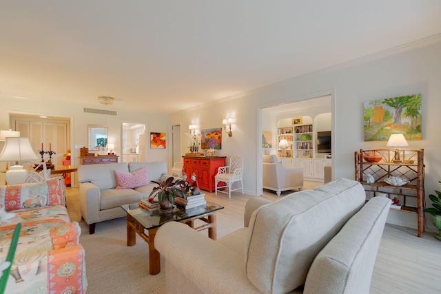 living area with ornamental molding, baseboards, visible vents, and light wood finished floors