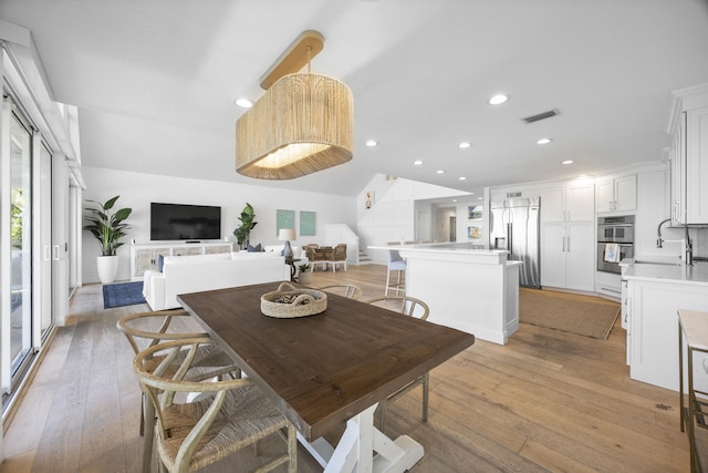 dining room featuring recessed lighting, visible vents, vaulted ceiling, and light wood finished floors