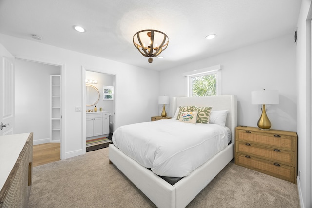 bedroom with light carpet, connected bathroom, a notable chandelier, and recessed lighting