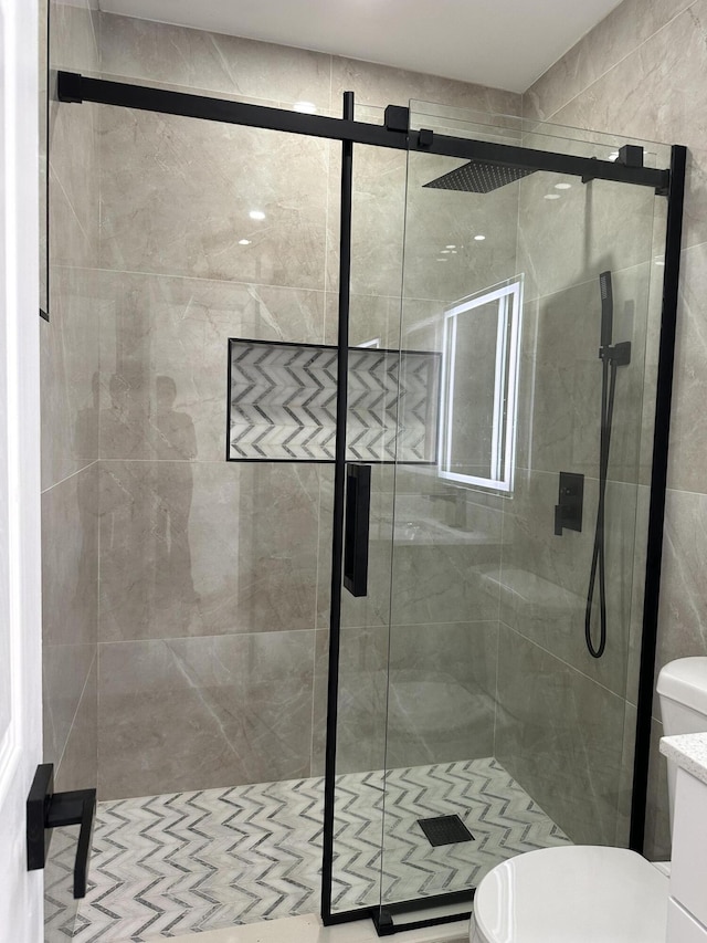 bathroom with a shower stall and toilet