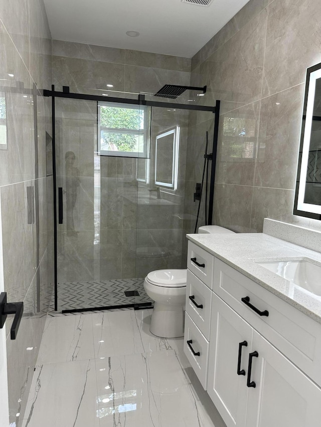 full bath with toilet, marble finish floor, a shower stall, and vanity