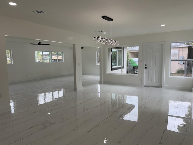 unfurnished dining area featuring marble finish floor, plenty of natural light, visible vents, and baseboards