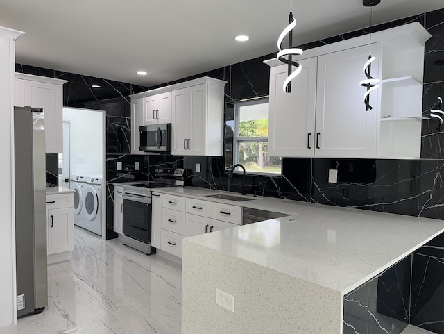 kitchen featuring a peninsula, marble finish floor, stainless steel appliances, separate washer and dryer, and a sink