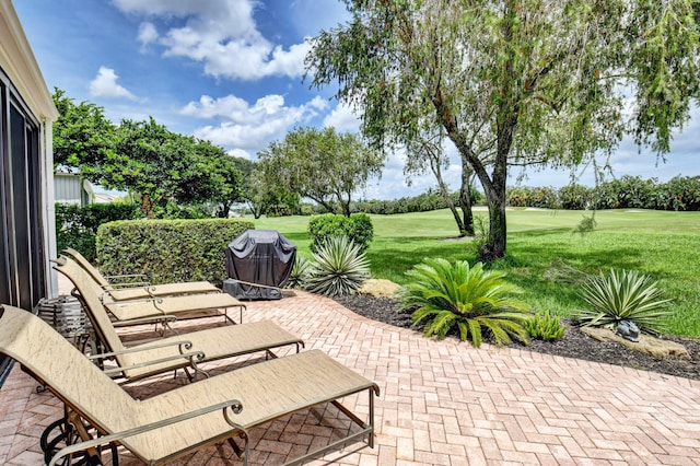 view of patio featuring golf course view and a grill