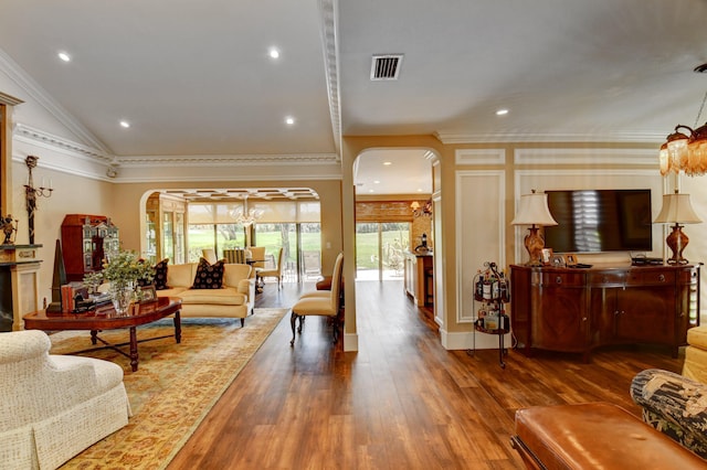 living area featuring arched walkways, a healthy amount of sunlight, visible vents, and wood finished floors