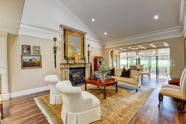 living area with high vaulted ceiling, wood finished floors, a glass covered fireplace, and crown molding