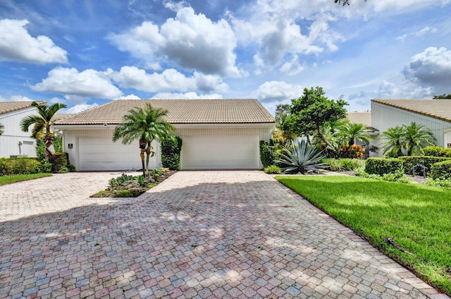 view of front of home with a garage, decorative driveway, and a tiled roof