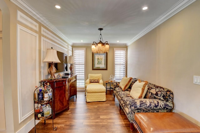 sitting room with a notable chandelier, recessed lighting, wood finished floors, and crown molding