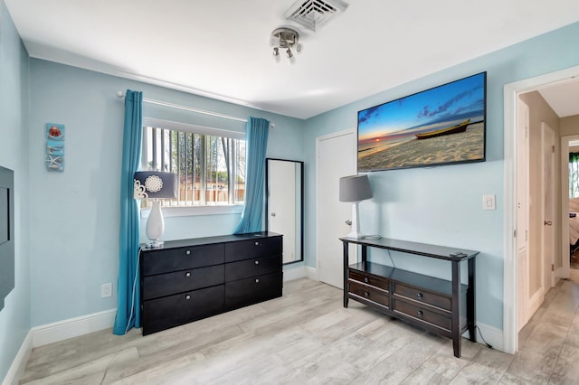 bedroom featuring visible vents, baseboards, and wood finished floors