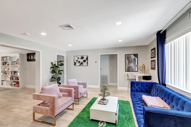 living room with light wood finished floors, recessed lighting, visible vents, and baseboards