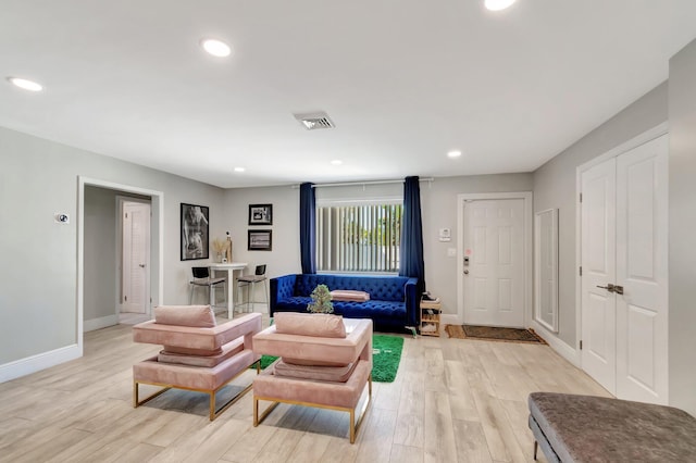 living area featuring baseboards, recessed lighting, visible vents, and light wood-style floors