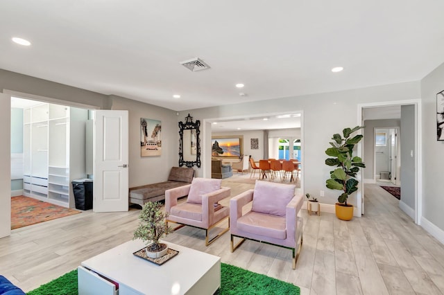 living area with light wood-style floors, baseboards, visible vents, and recessed lighting